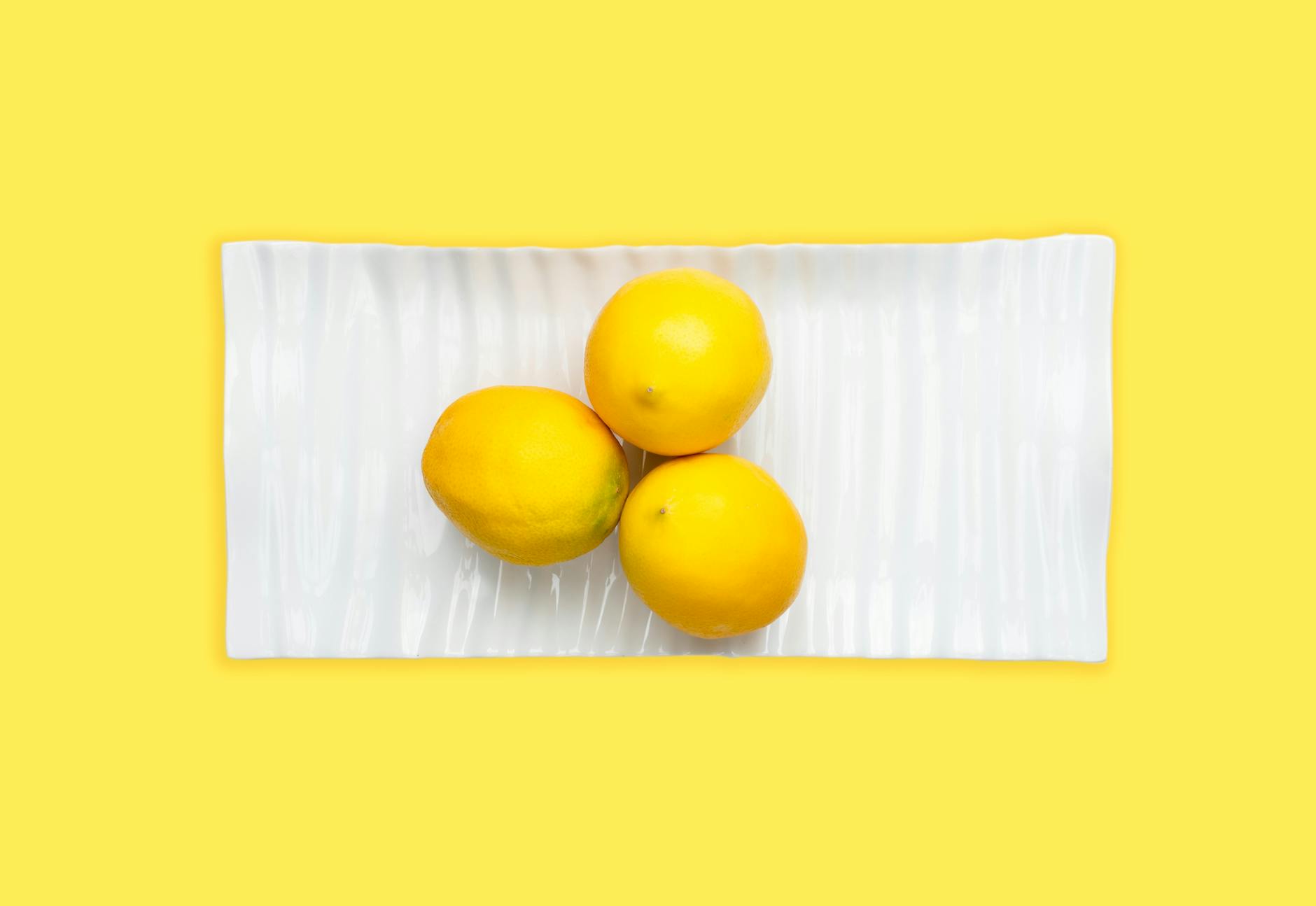 Fresh lemons on a white plate, symbolizing renewal and restored sensation during stress recovery