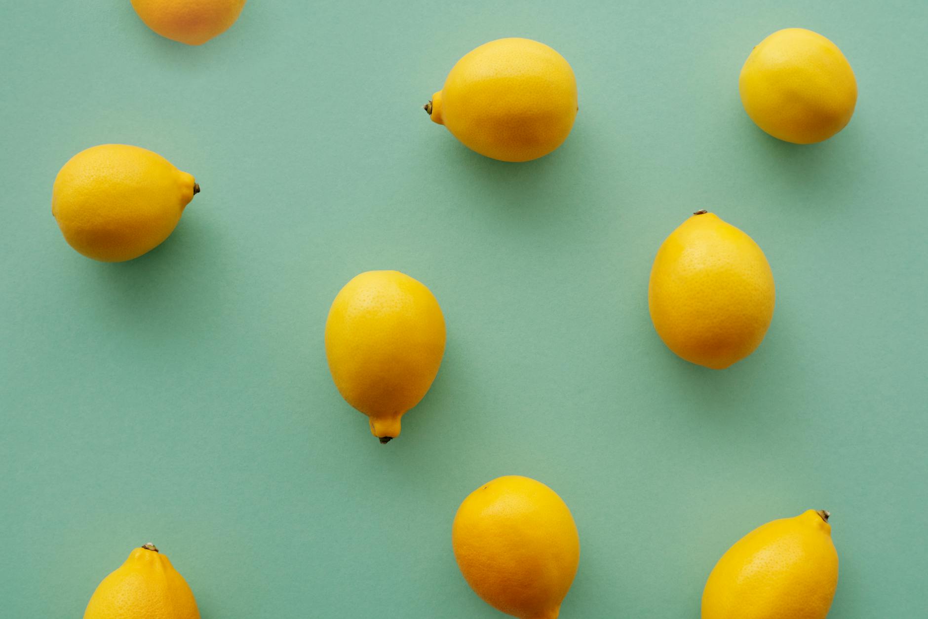 Bright yellow lemons on pastel green background, representing fresh sensation and renewal